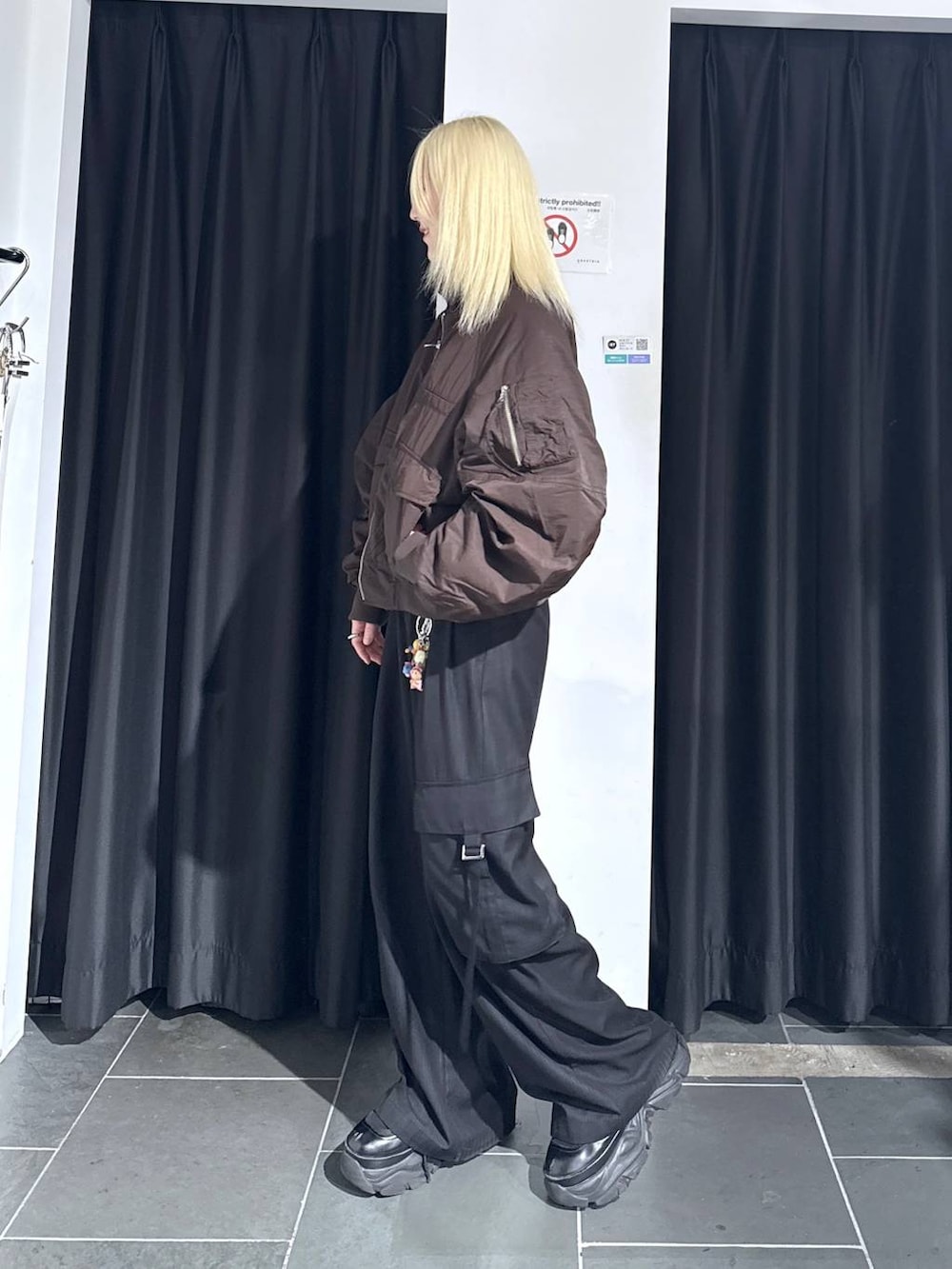 ブラック系のブーツ、ブラック系のスラックス、ブラウン系のブルゾンを着用したレディースの秋コーディネートの2枚目の写真