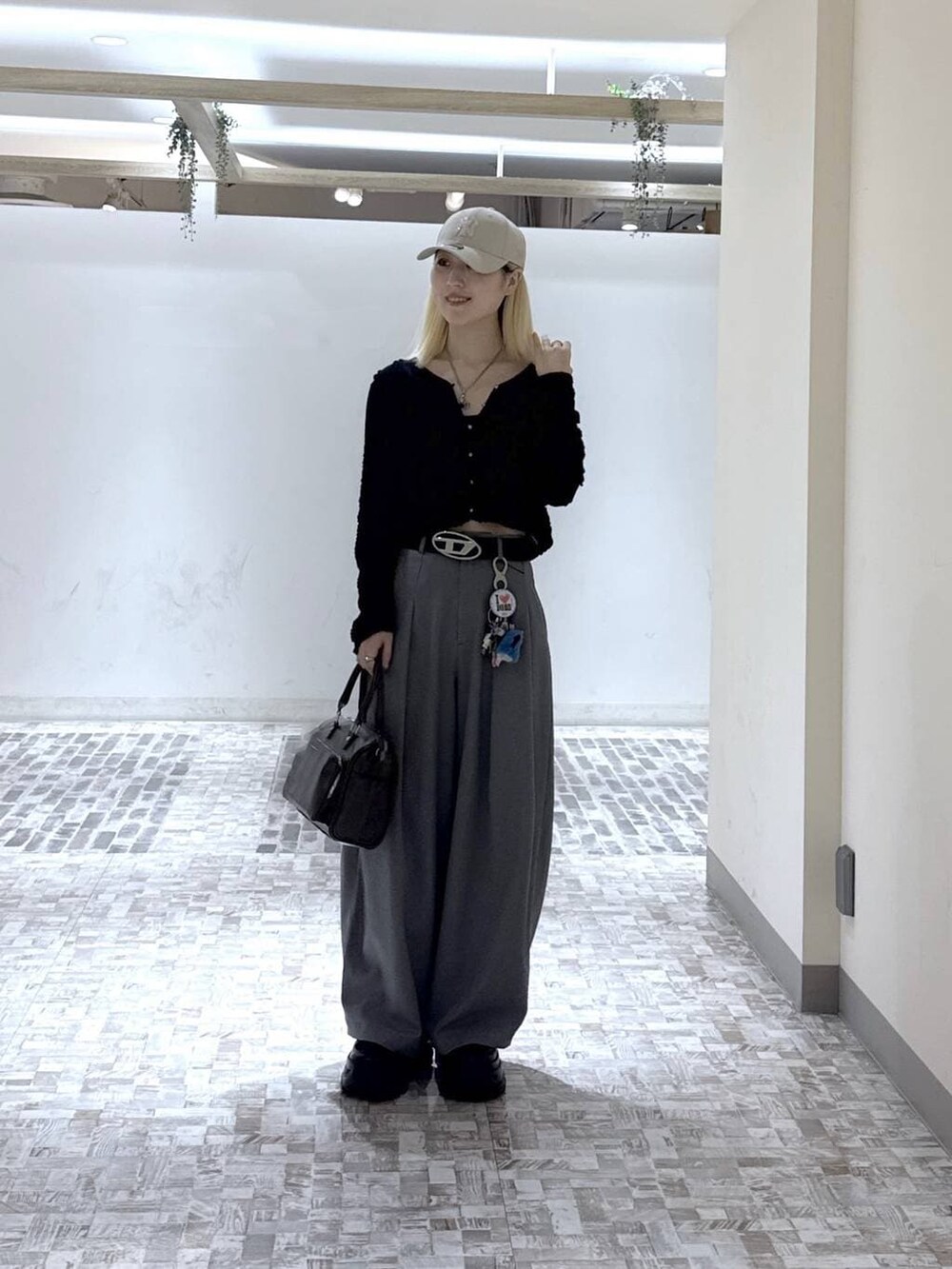 ブラック系のスニーカー、ブラック系のTシャツ/カットソー、グレー系のスラックスを着用したレディースの春コーディネートの3枚目の写真