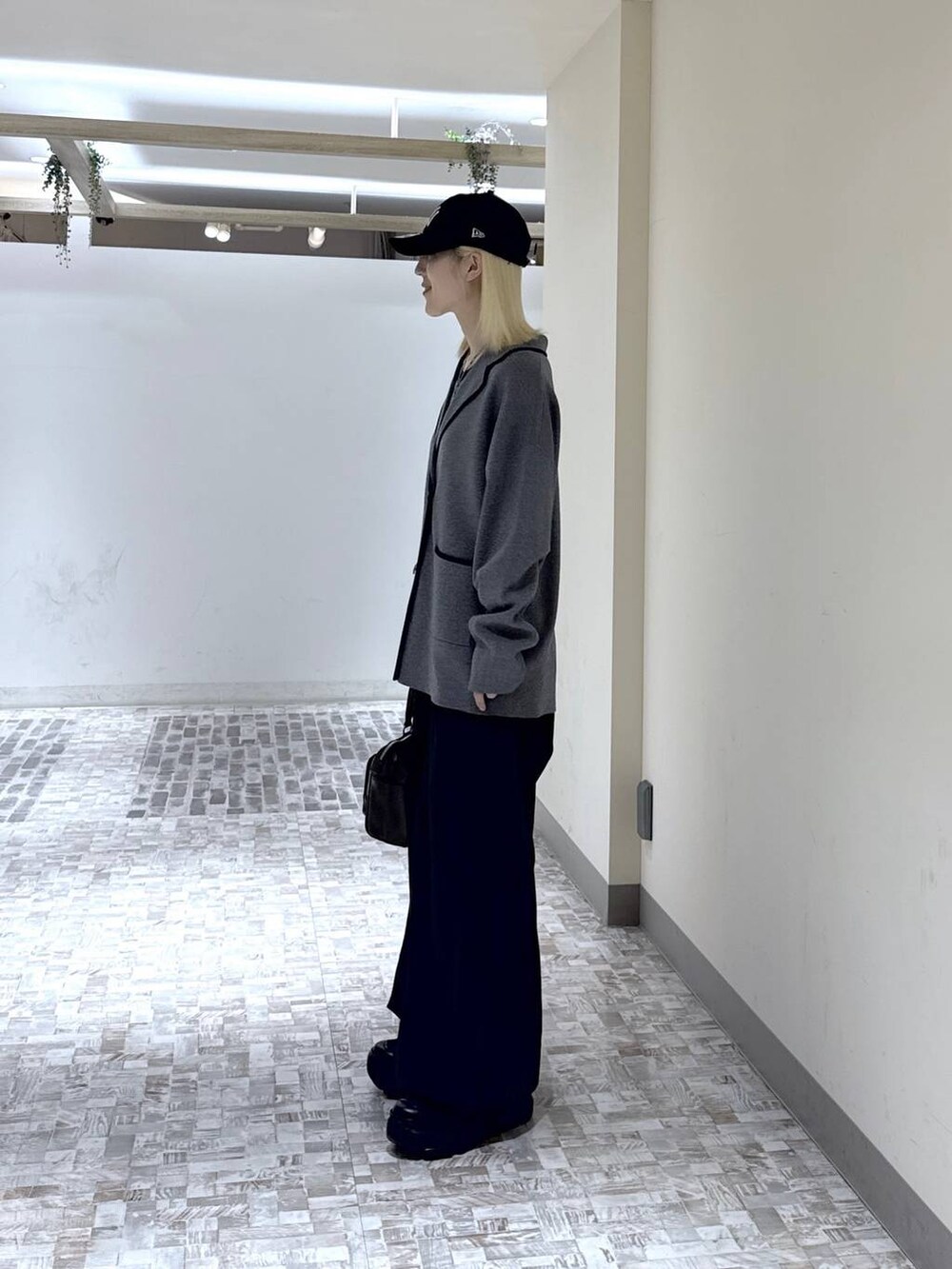 ブラック系のスニーカー、ブラック系のデニムパンツ、グレー系のテーラードジャケットを着用したレディースの冬コーディネートの5枚目の写真
