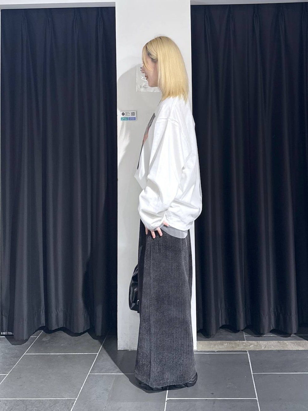 ブラック系のスニーカー、グレー系のその他パンツ、ブラック系のショルダーバッグを着用したレディースの秋コーディネートの3枚目の写真