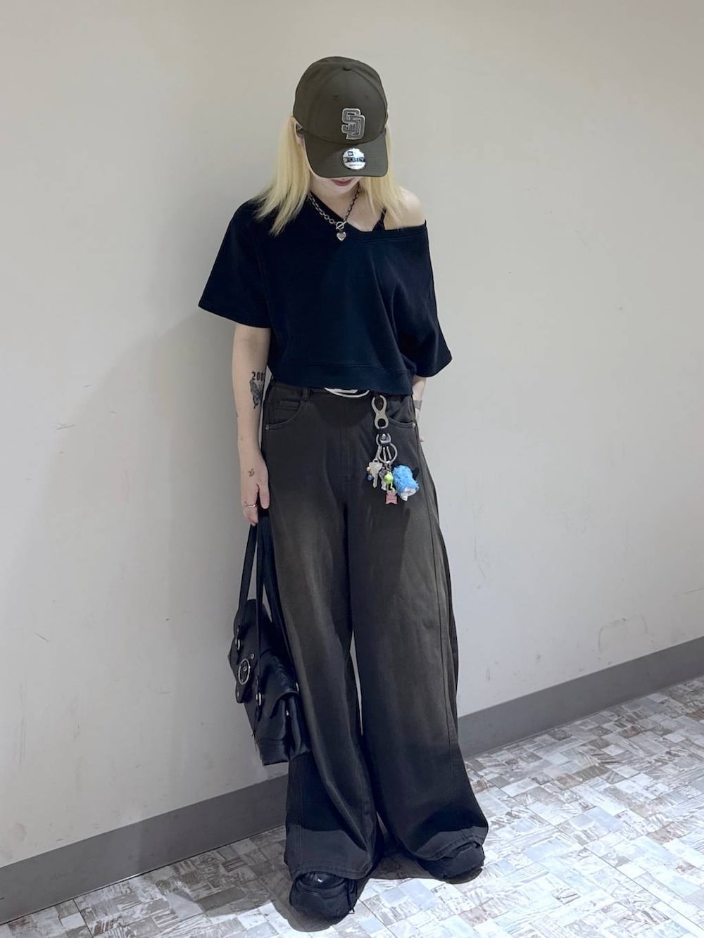 ブラウン系のデニムパンツ、ブラック系のスウェット、ブラック系のブーツを着用したレディースの夏コーディネートの2枚目の写真