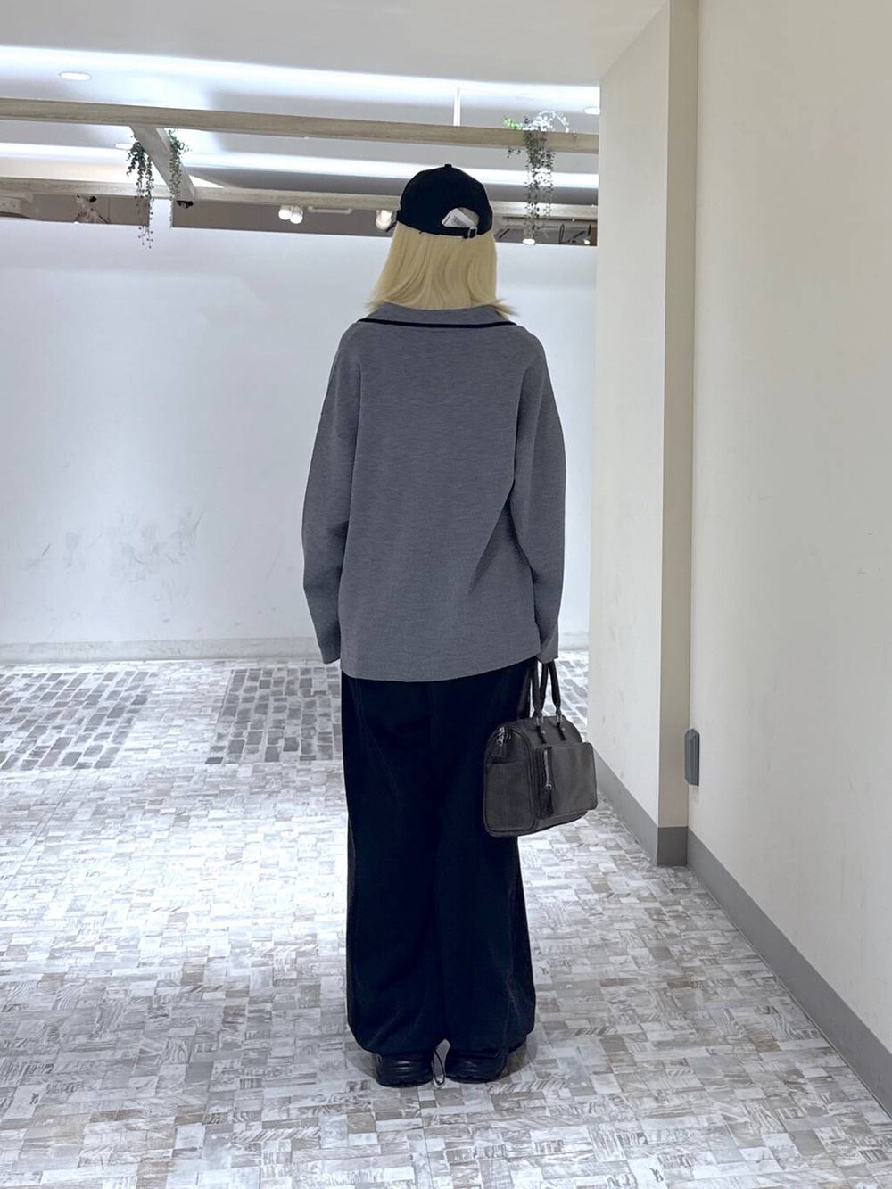 ブラック系のスニーカー、ブラック系のデニムパンツ、グレー系のテーラードジャケットを着用したレディースの冬コーディネートの6枚目の写真