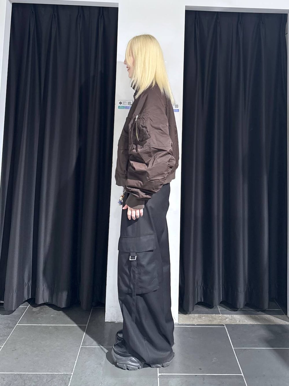 ブラック系のブーツ、ブラック系のスラックス、ブラウン系のブルゾンを着用したレディースの秋コーディネートの4枚目の写真