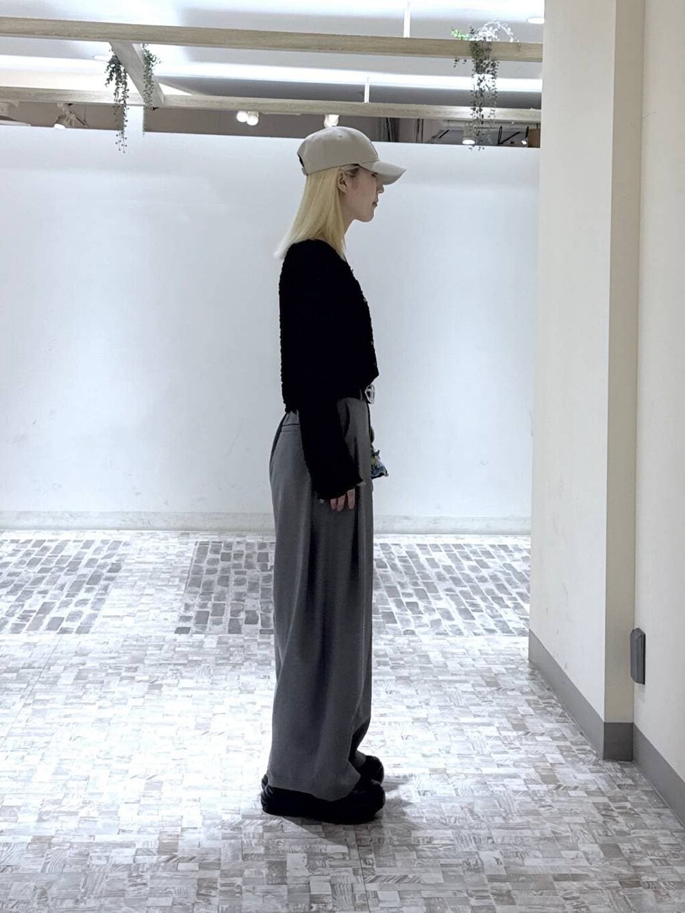 ブラック系のスニーカー、ブラック系のTシャツ/カットソー、グレー系のスラックスを着用したレディースの春コーディネートの6枚目の写真