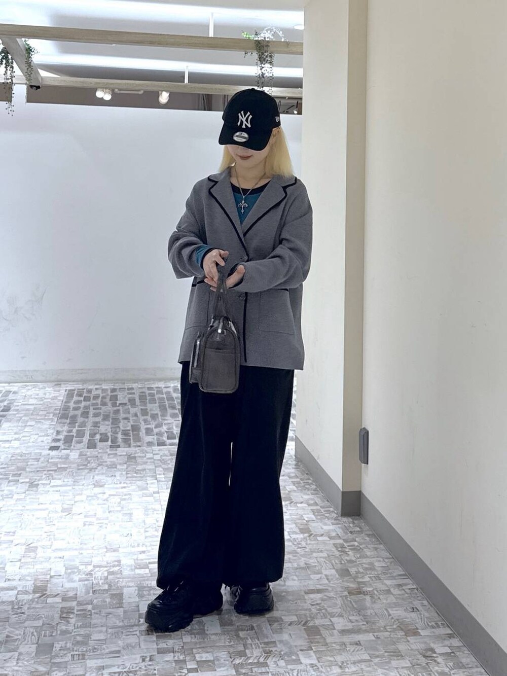 ブラック系のスニーカー、ブラック系のデニムパンツ、グレー系のテーラードジャケットを着用したレディースの冬コーディネートの2枚目の写真