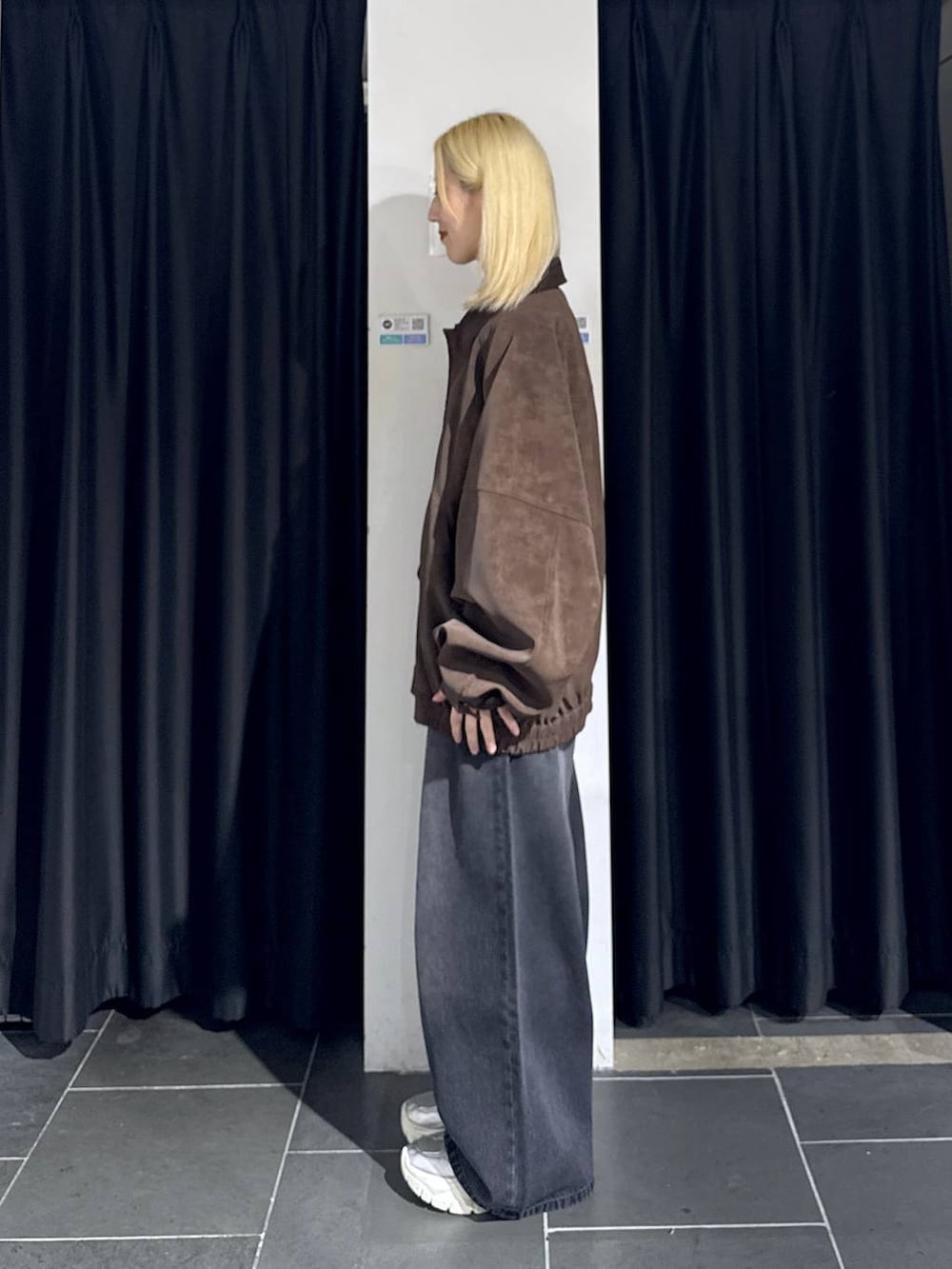 ブラック系のデニムパンツ、シルバー系のスニーカー、ブラウン系のブルゾンを着用したレディースの秋コーディネートの3枚目の写真