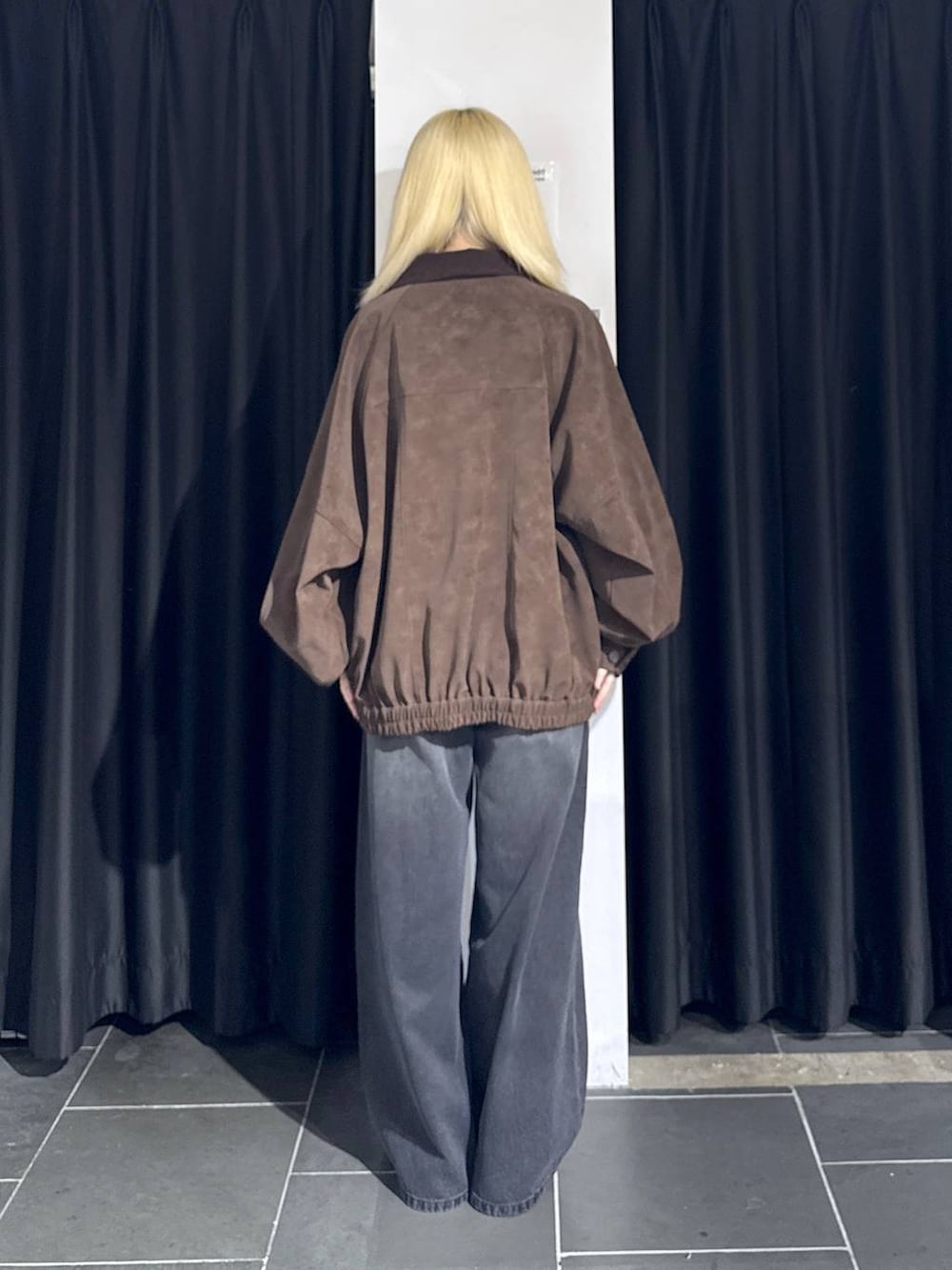 ブラック系のデニムパンツ、シルバー系のスニーカー、ブラウン系のブルゾンを着用したレディースの秋コーディネートの4枚目の写真