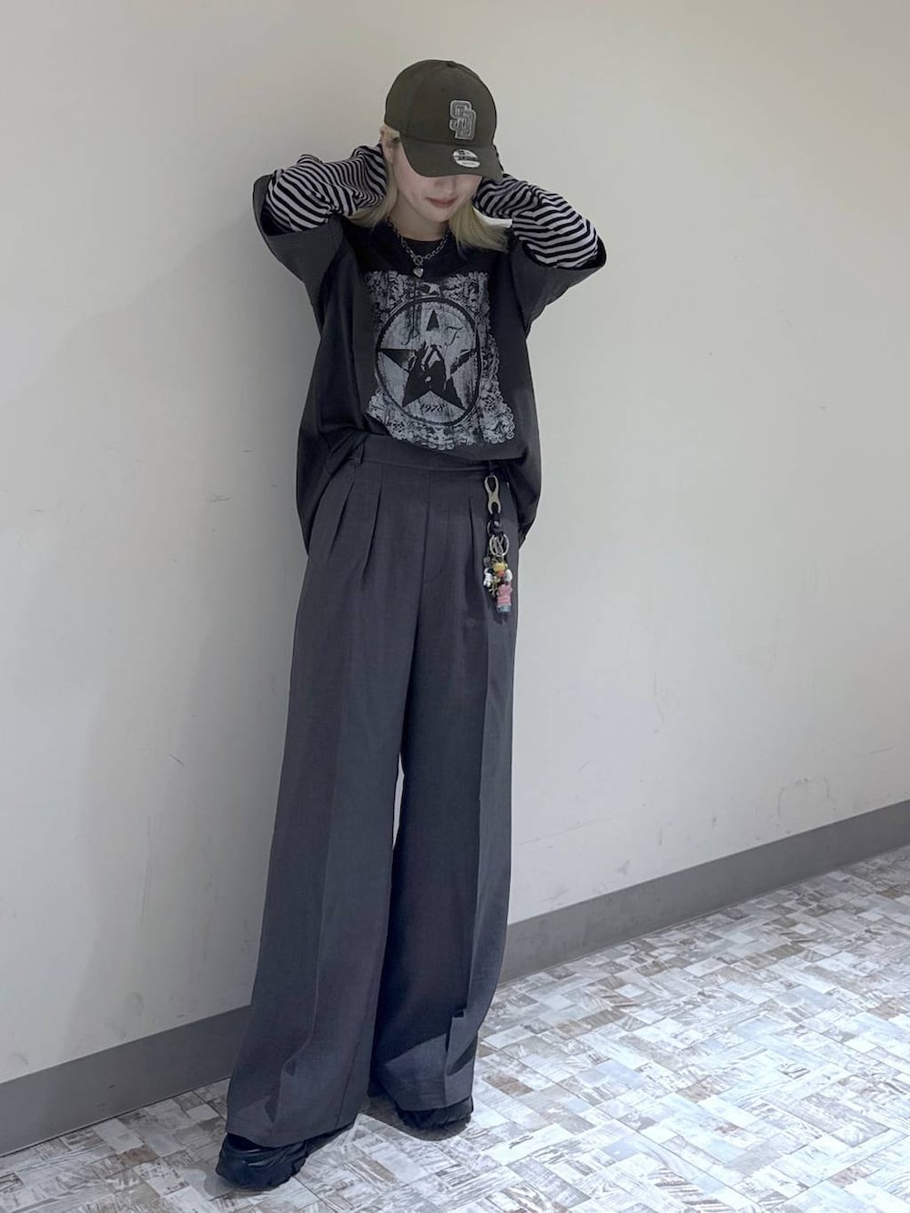 グレー系のスラックス、ブラック系のボストンバッグ、グリーン系のTシャツ/カットソーを着用したレディースの夏コーディネートの2枚目の写真