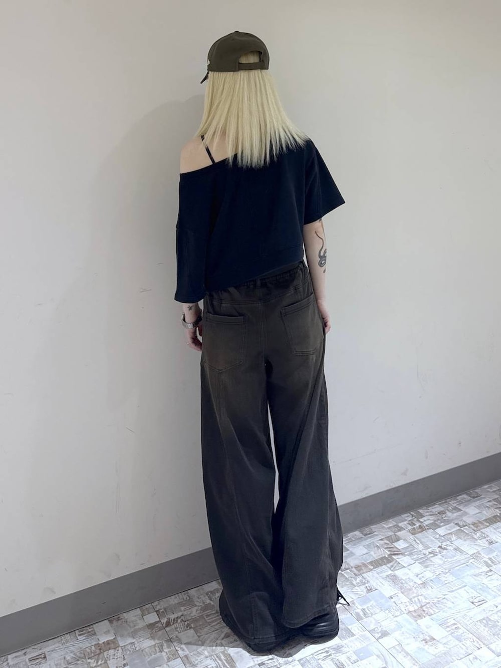 ブラウン系のデニムパンツ、ブラック系のスウェット、ブラック系のブーツを着用したレディースの夏コーディネートの4枚目の写真