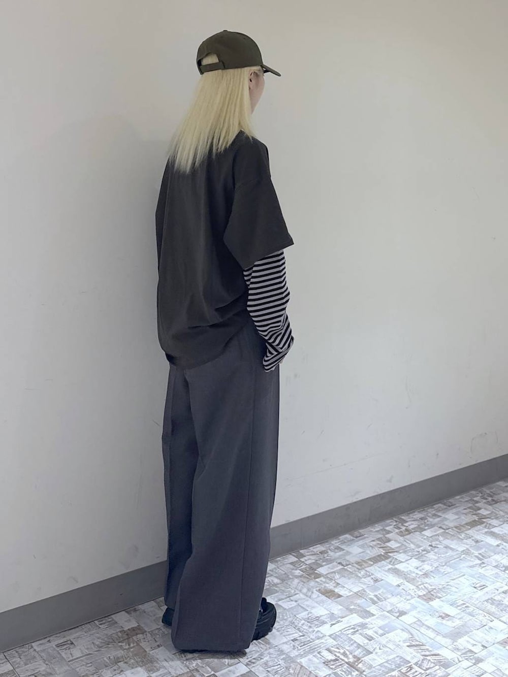 グレー系のスラックス、ブラック系のボストンバッグ、グリーン系のTシャツ/カットソーを着用したレディースの夏コーディネートの6枚目の写真