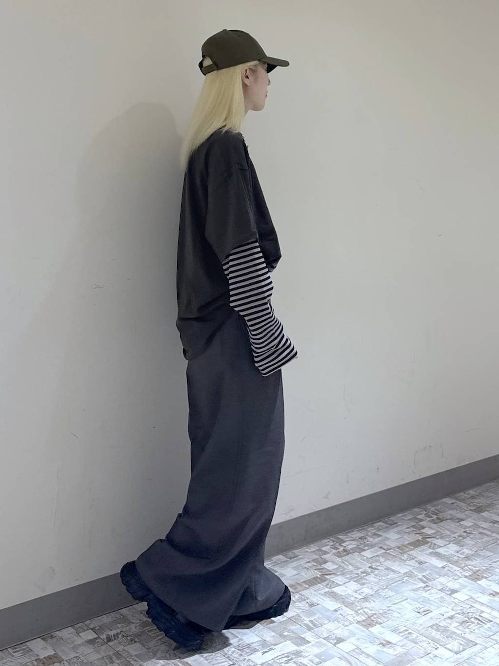 グレー系のスラックス、ブラック系のボストンバッグ、グリーン系のTシャツ/カットソーを着用したレディースの夏コーディネートの3枚目の写真