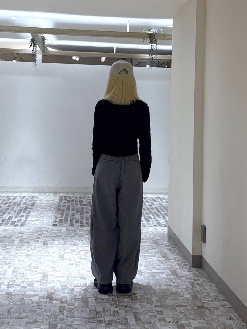 ブラック系のスニーカー、ブラック系のTシャツ/カットソー、グレー系のスラックスを着用したレディースの春コーディネートの5枚目の写真