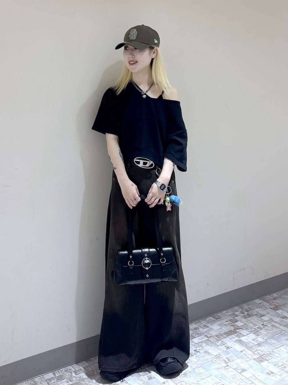 ブラウン系のデニムパンツ、ブラック系のスウェット、ブラック系のブーツを着用したレディースの夏コーディネートの6枚目の写真