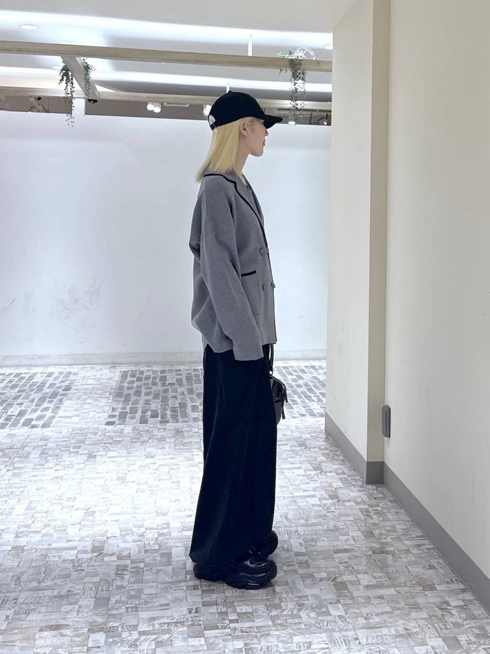 ブラック系のスニーカー、ブラック系のデニムパンツ、グレー系のテーラードジャケットを着用したレディースの冬コーディネートの7枚目の写真