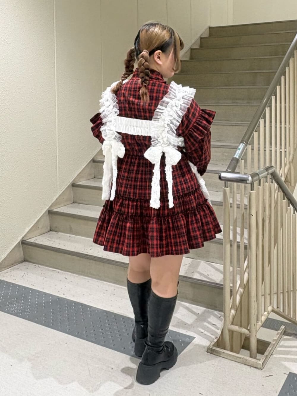 ブラック系のブーツ、レッド系のワンピース、ブラック系のボストンバッグを着用したレディースの冬コーディネートの4枚目の写真