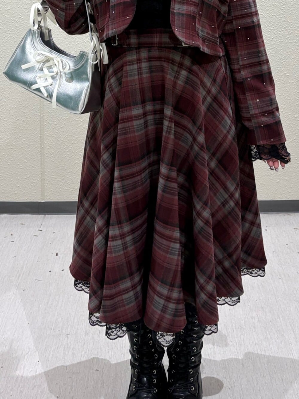 ブラック系のブーツ、レッド系のテーラードジャケット、レッド系のスカートを着用したレディースの冬コーディネートの6枚目の写真