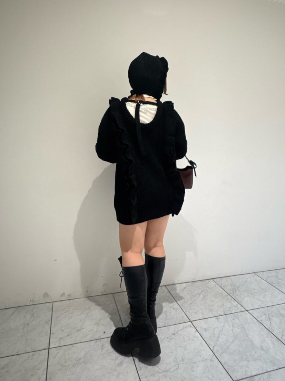 ホワイト系のニット/セーター、ブラック系のブーツ、ブラック系のニット/セーターを着用したレディースの冬コーディネートの3枚目の写真