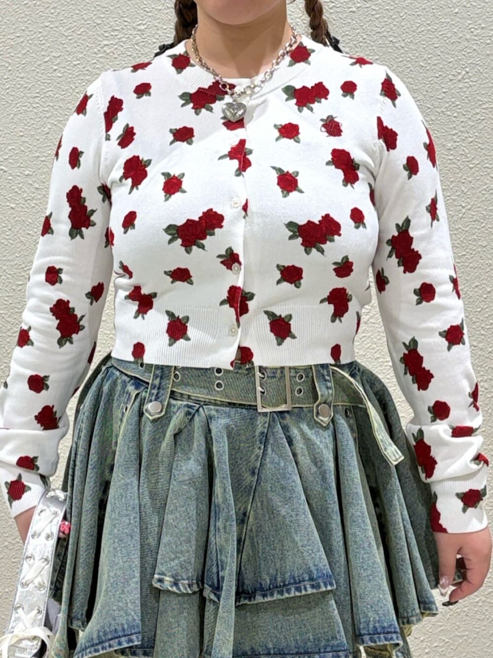 シルバー系のハンドバッグ、ホワイト系のカーディガン/ボレロ、ブルー系のデニムスカートを着用したレディースの春コーディネートの6枚目の写真