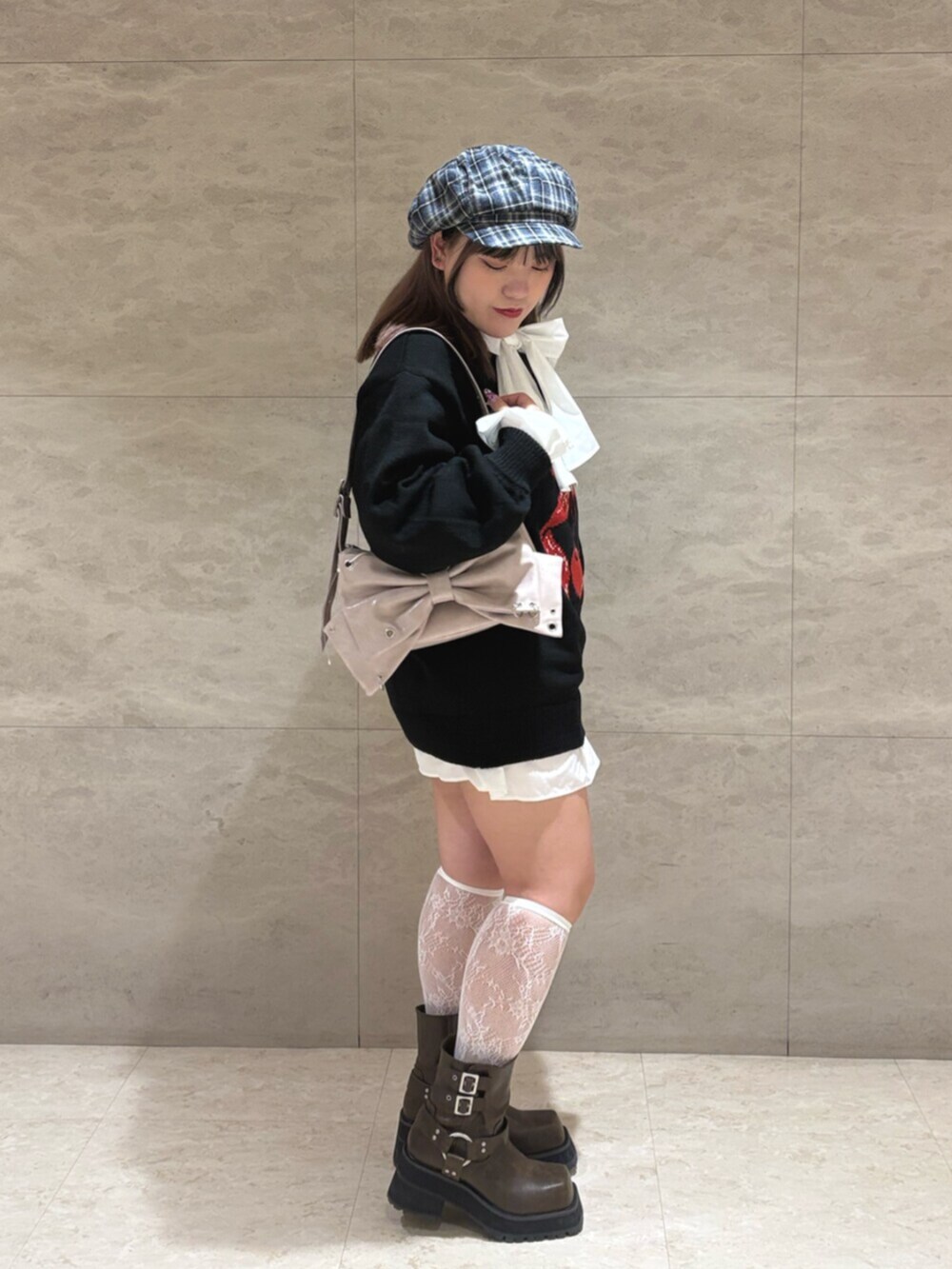 ブラック系のニット/セーター、ピンク系のショルダーバッグ、ブラウン系のブーツを着用したレディースの秋コーディネートの2枚目の写真