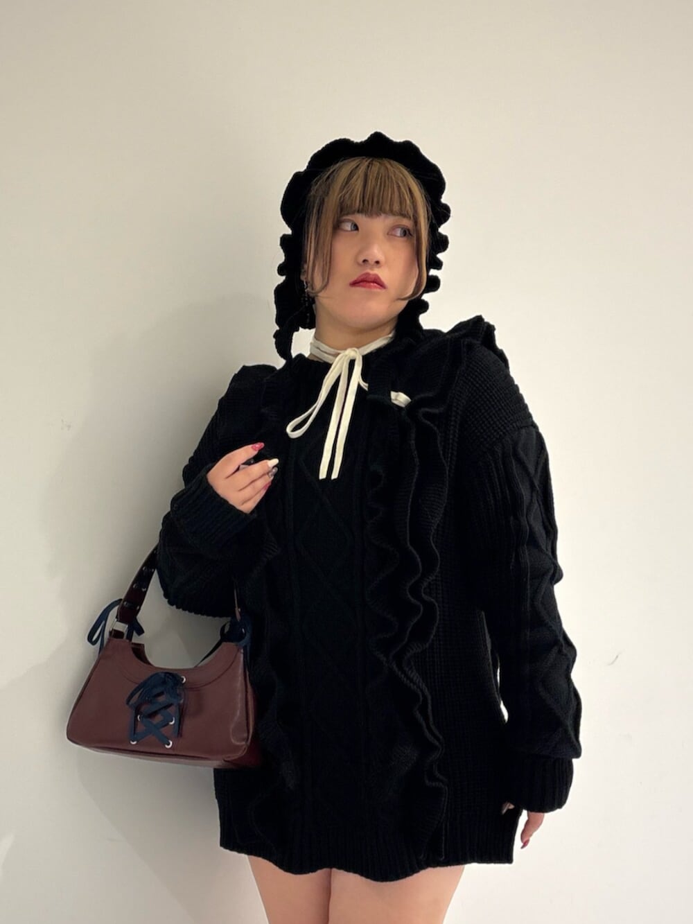 ホワイト系のニット/セーター、ブラック系のブーツ、ブラック系のニット/セーターを着用したレディースの冬コーディネートの4枚目の写真