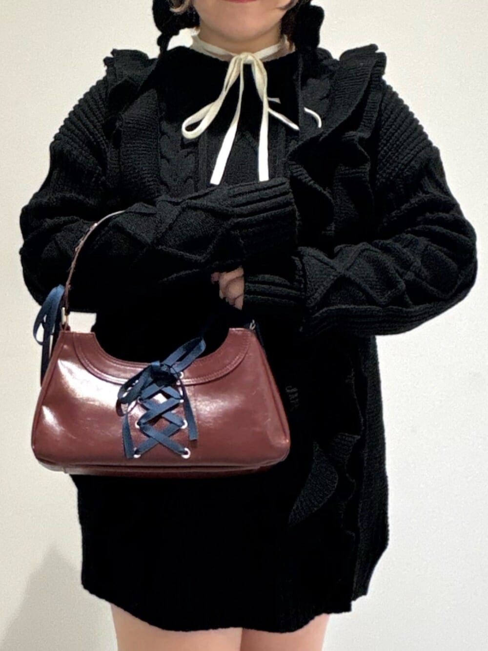 ホワイト系のニット/セーター、ブラック系のブーツ、ブラック系のニット/セーターを着用したレディースの冬コーディネートの5枚目の写真