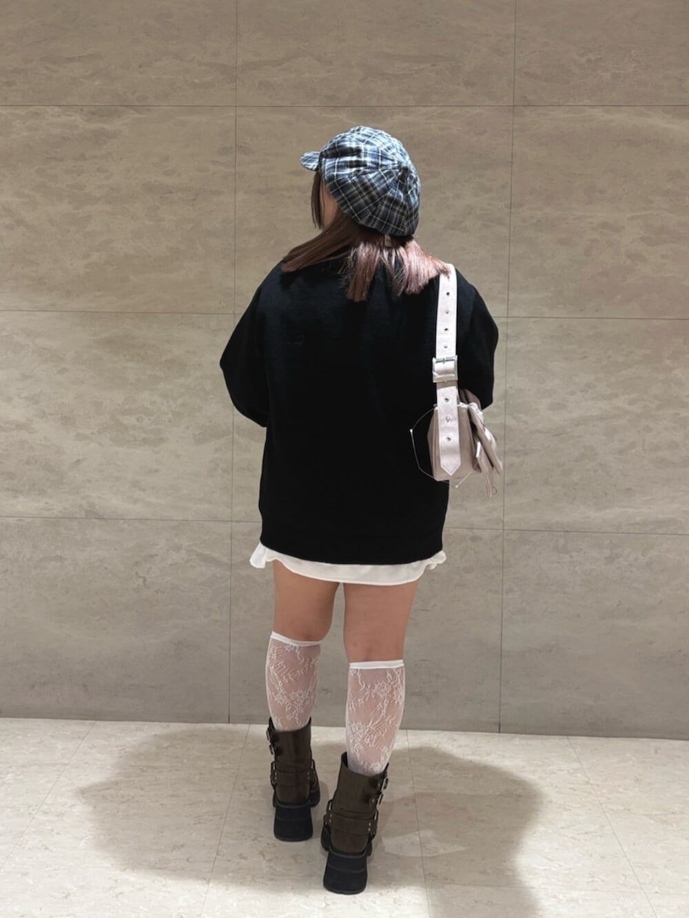 ブラック系のニット/セーター、ピンク系のショルダーバッグ、ブラウン系のブーツを着用したレディースの秋コーディネートの3枚目の写真