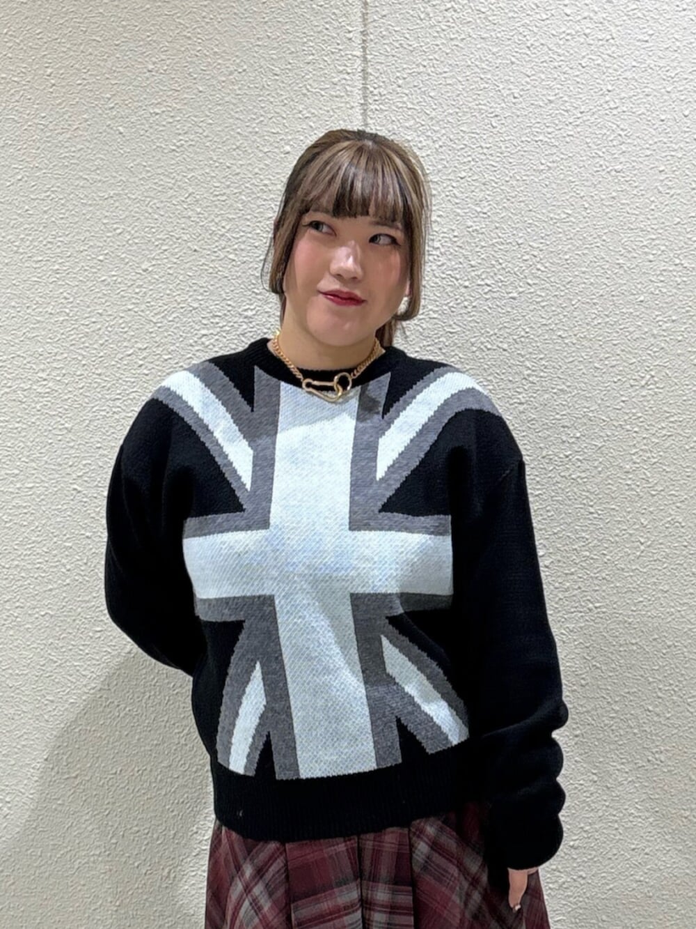 ブラック系のブーツ、レッド系のスカート、ブラック系のニット/セーターを着用したレディースの冬コーディネートの4枚目の写真