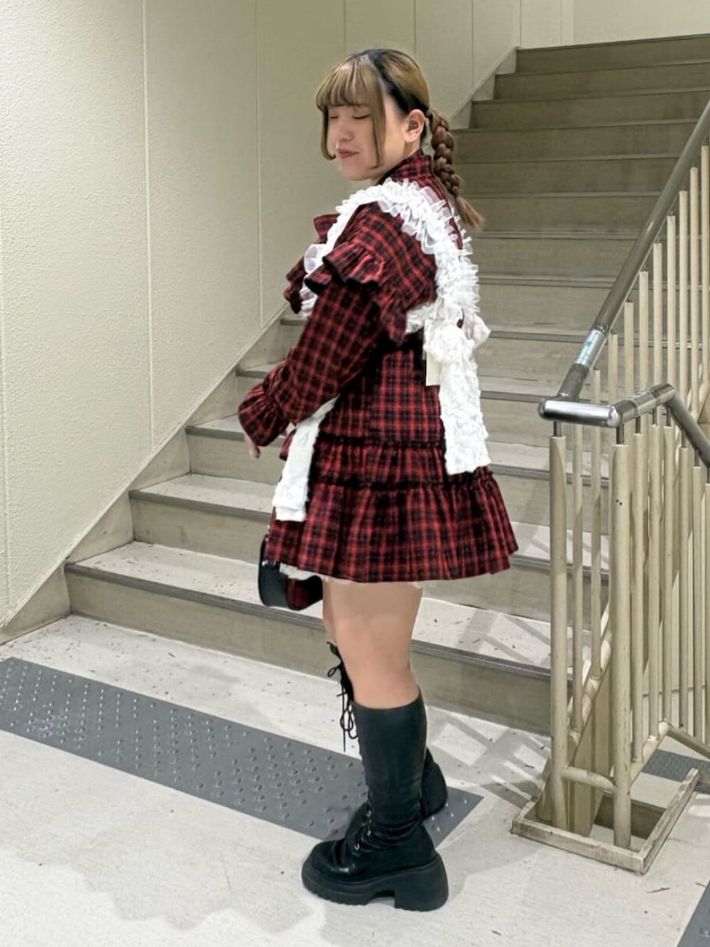 ブラック系のブーツ、レッド系のワンピース、ブラック系のボストンバッグを着用したレディースの冬コーディネートの3枚目の写真