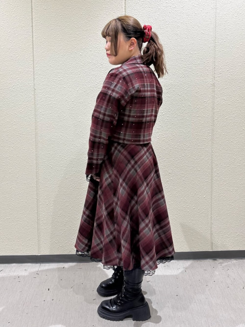 ブラック系のブーツ、レッド系のテーラードジャケット、レッド系のスカートを着用したレディースの冬コーディネートの2枚目の写真