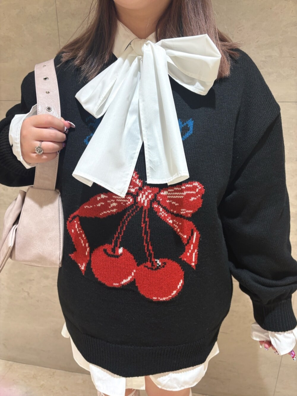 ブラック系のニット/セーター、ピンク系のショルダーバッグ、ブラウン系のブーツを着用したレディースの秋コーディネートの5枚目の写真