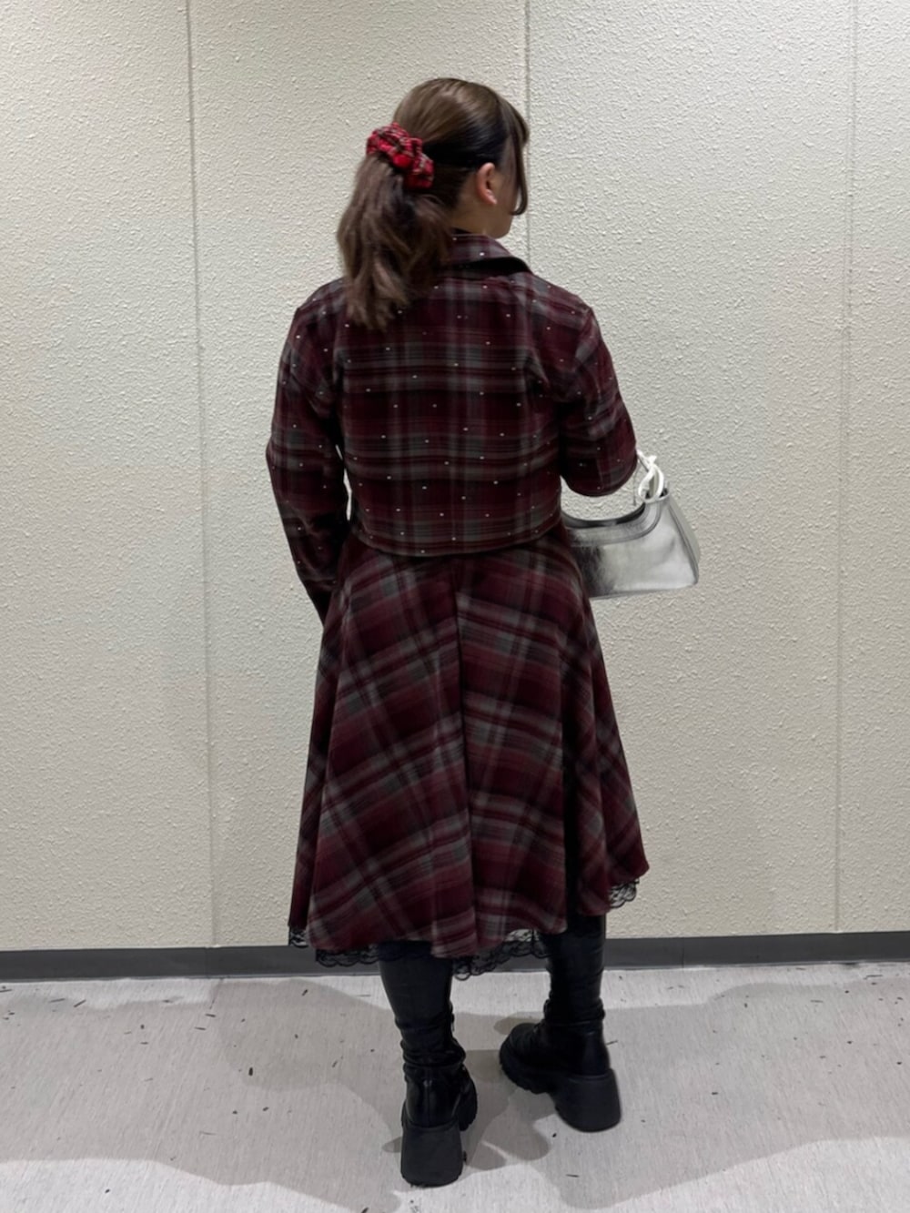 ブラック系のブーツ、レッド系のテーラードジャケット、レッド系のスカートを着用したレディースの冬コーディネートの3枚目の写真