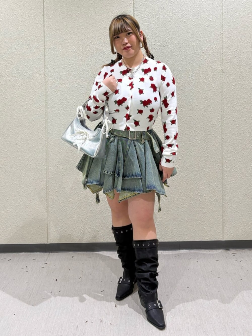 シルバー系のハンドバッグ、ホワイト系のカーディガン/ボレロ、ブルー系のデニムスカートを着用したレディースの春コーディネートの2枚目の写真