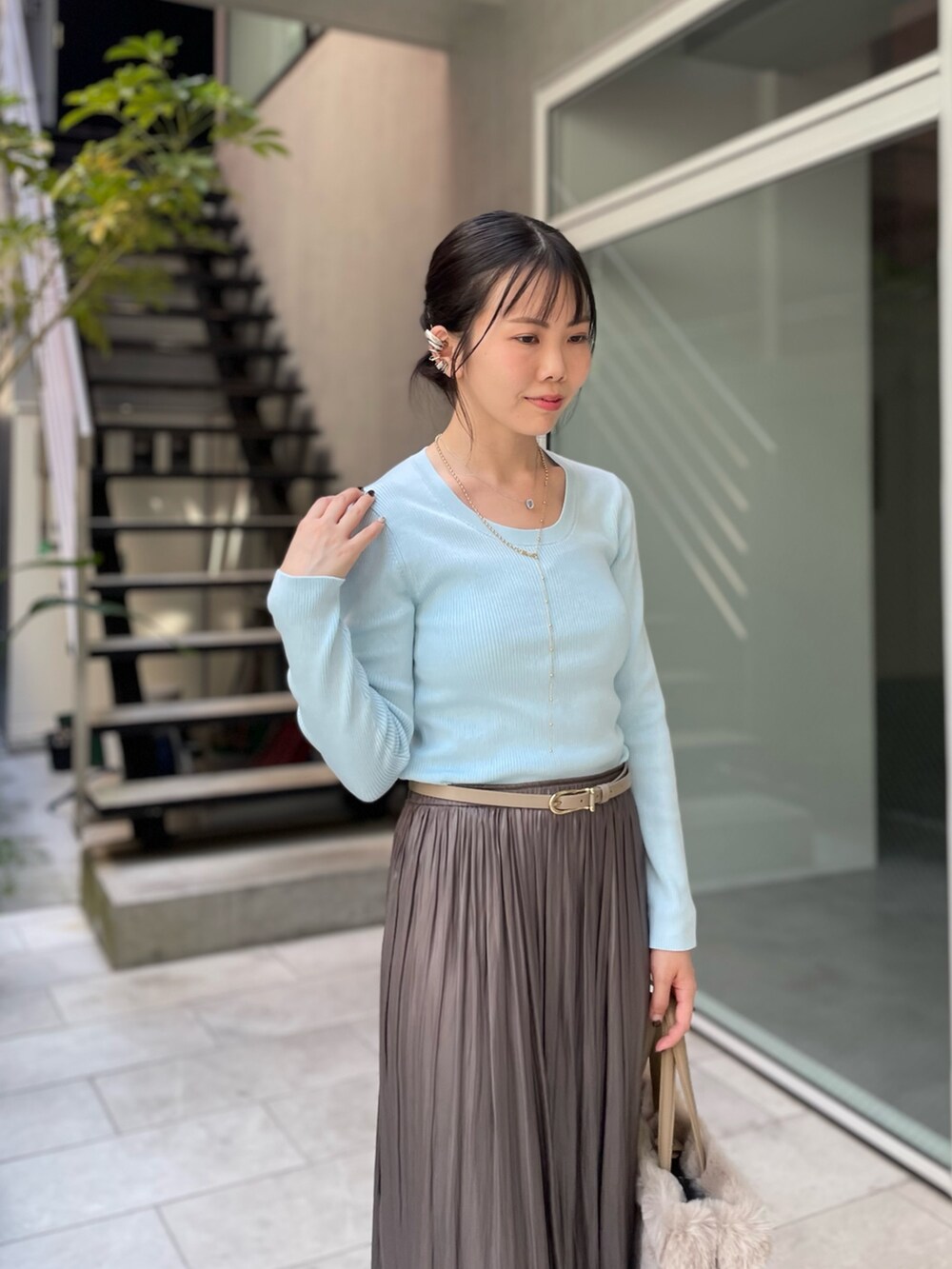 ブルー系のニット/セーター、グリーン系のスカート、ベージュ系のトートバッグを着用したレディースの秋コーディネートの5枚目の写真