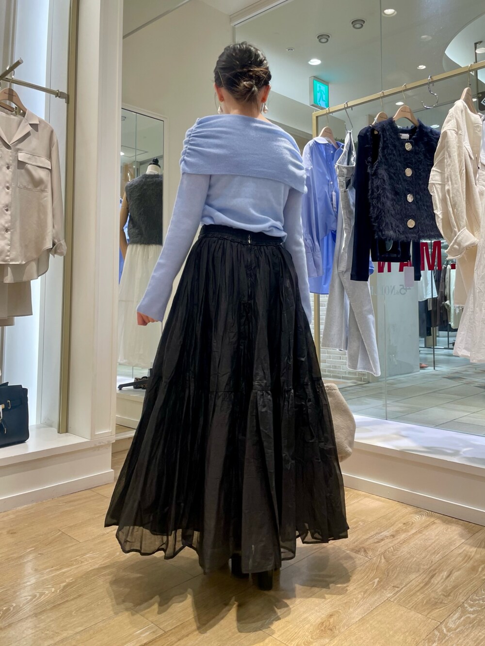 グレー系のニット/セーター、ベージュ系のショルダーバッグを着用したレディースの秋コーディネートの4枚目の写真