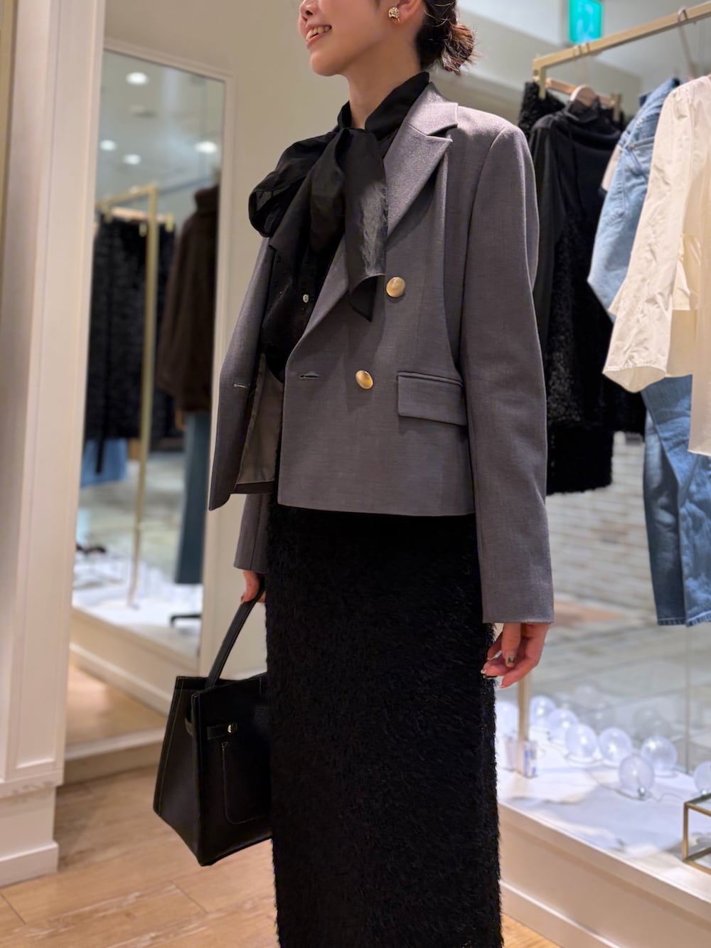 ブラック系のシャツ/ブラウス、グレー系のテーラードジャケット、イエロー系のその他アウターを着用したレディースの秋コーディネートの6枚目の写真