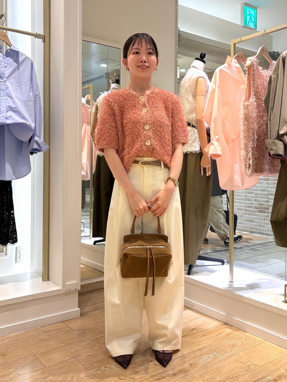 ピンク系のニット/セーター、ホワイト系のチノパンツ、イエロー系のショルダーバッグを着用したレディースの秋コーディネートの2枚目の写真