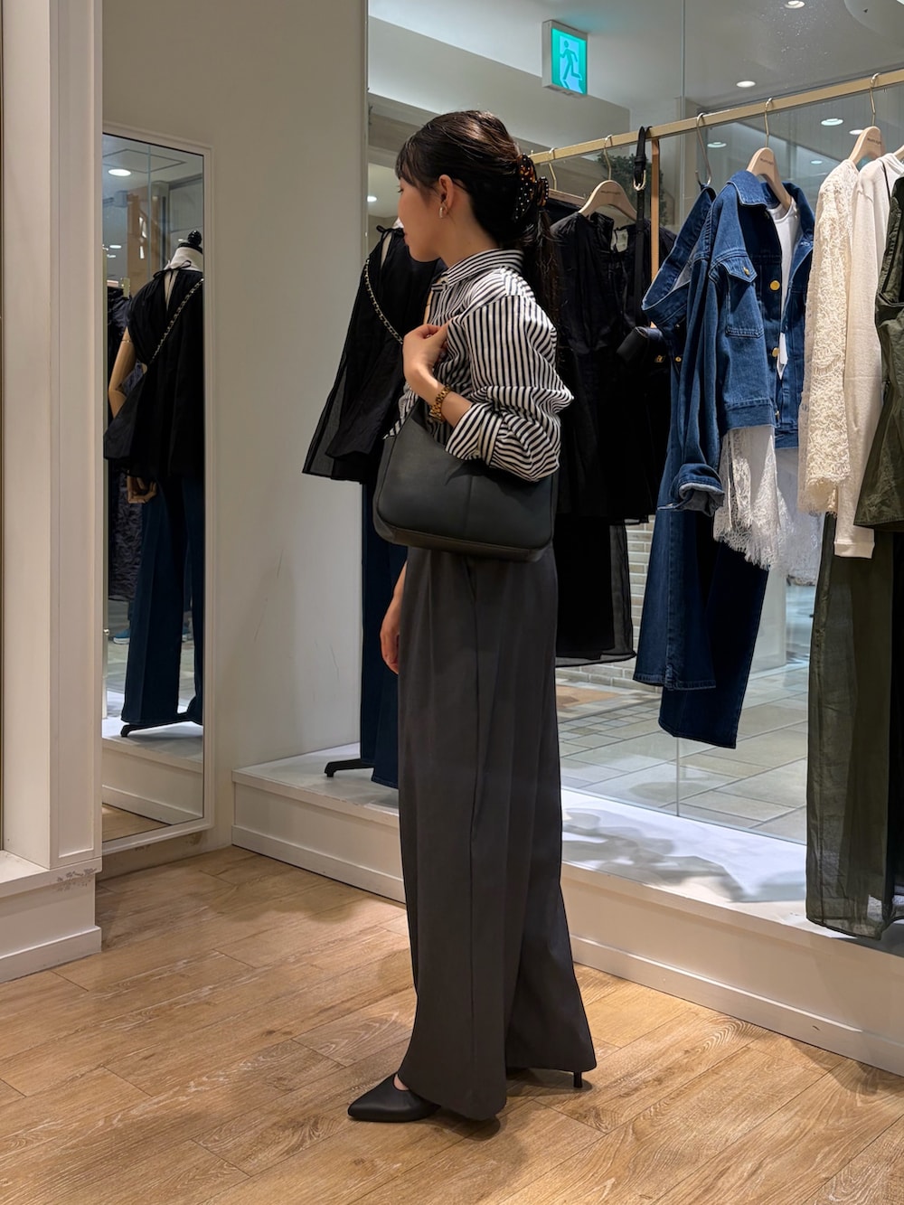 ブルー系のシャツ/ブラウス、ブラック系のショルダーバッグ、グレー系のその他パンツを着用したレディースの秋コーディネートの2枚目の写真