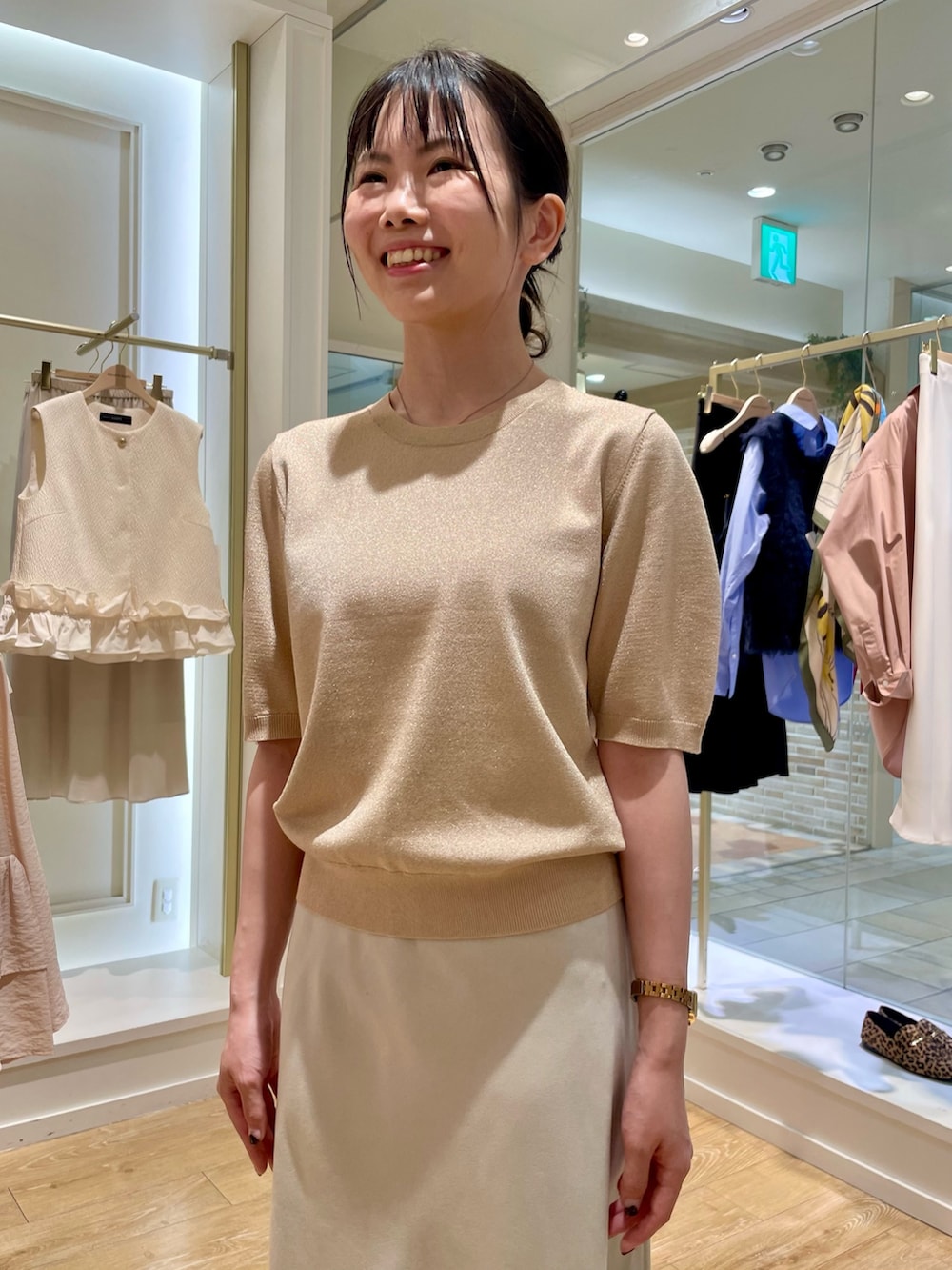 イエロー系のニット/セーター、ベージュ系のスカートを着用したレディースの秋コーディネートの8枚目の写真