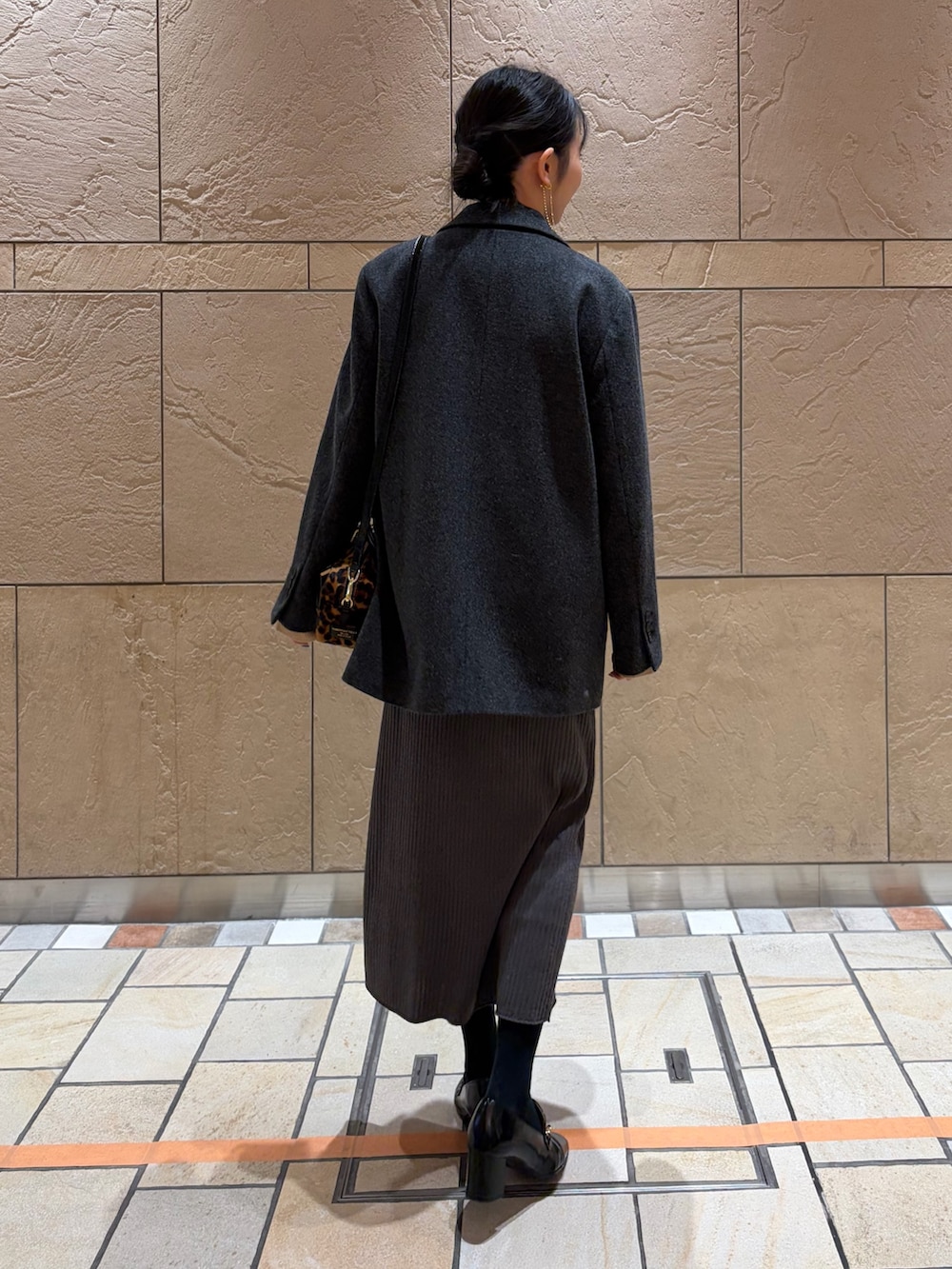 グレー系のテーラードジャケット、その他のボストンバッグ、ベージュ系のキャミソールを着用したレディースの冬コーディネートの3枚目の写真