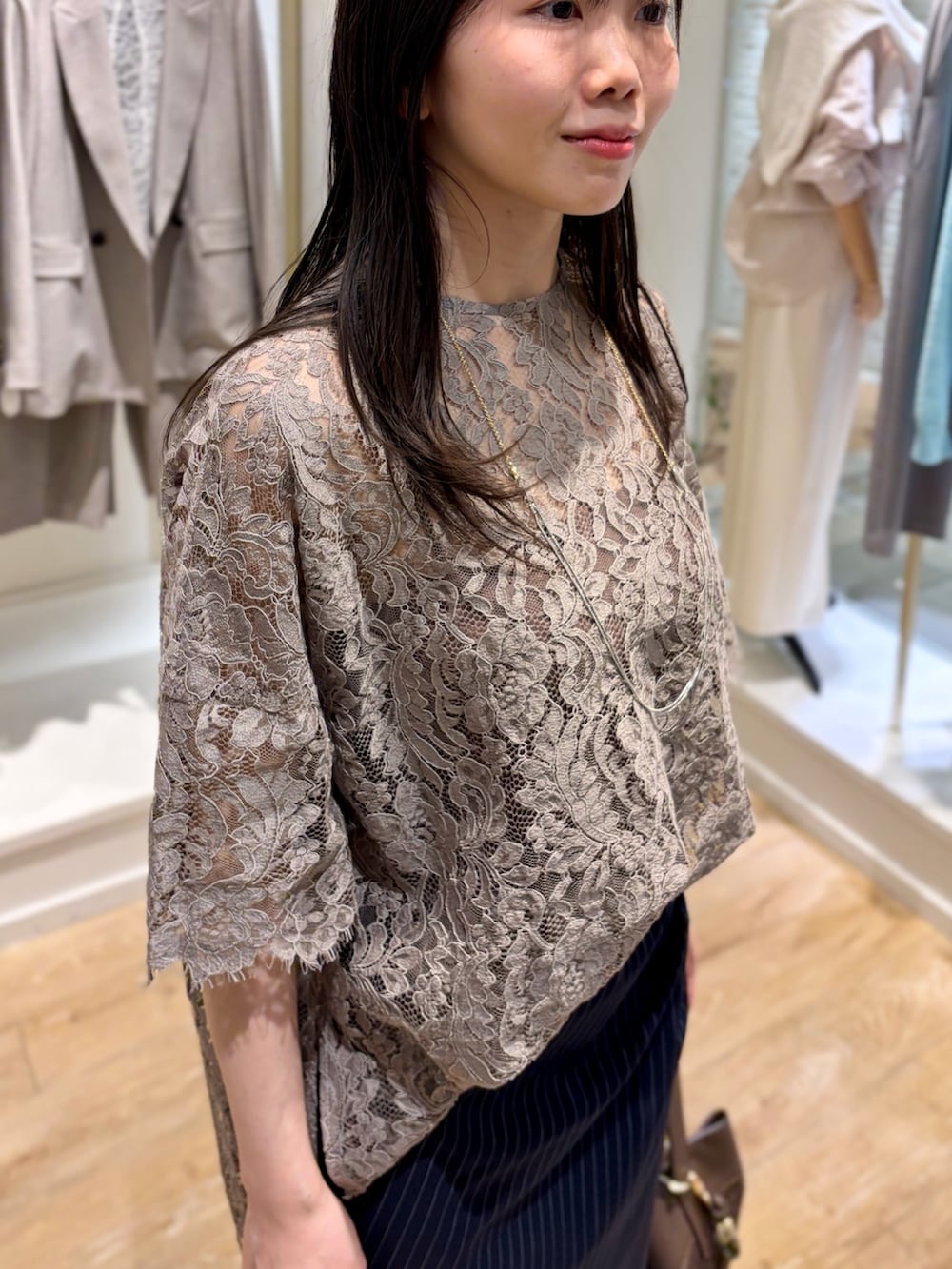 ブルー系のスカート、ブラウン系のショルダーバッグ、その他のネックレスを着用したレディースの冬コーディネートの6枚目の写真