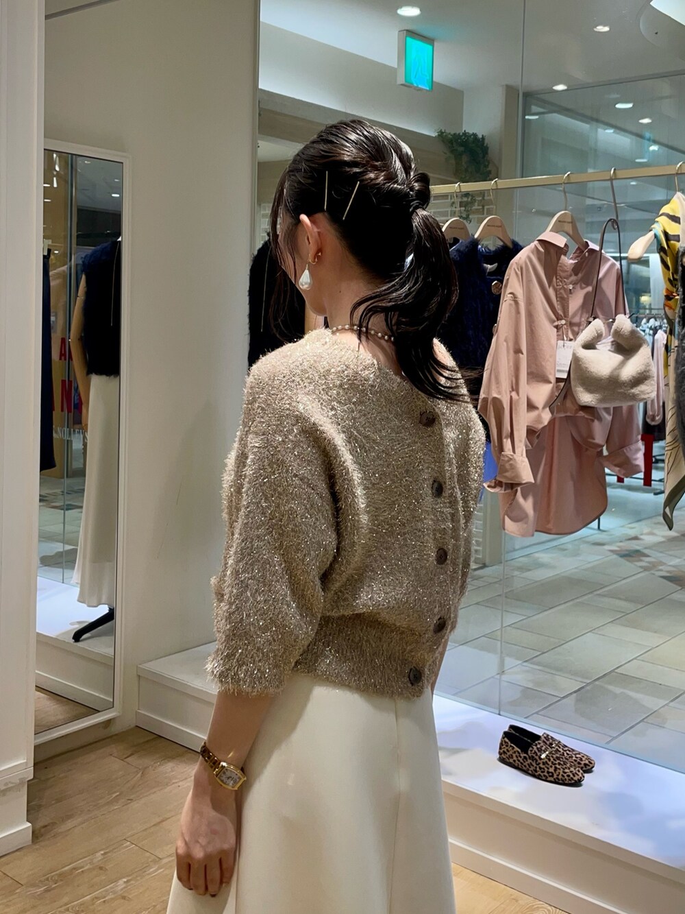 イエロー系のカーディガン/ボレロ、ホワイト系のスカート、ブラウン系のショルダーバッグを着用したレディースの秋コーディネートの10枚目の写真