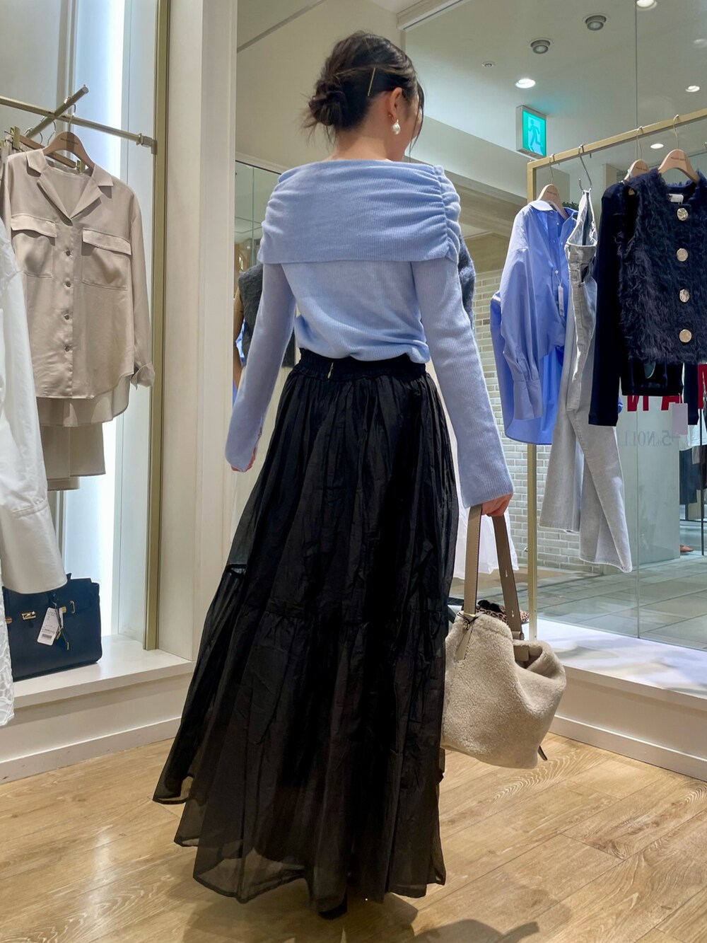 グレー系のニット/セーター、ベージュ系のショルダーバッグを着用したレディースの秋コーディネートの5枚目の写真