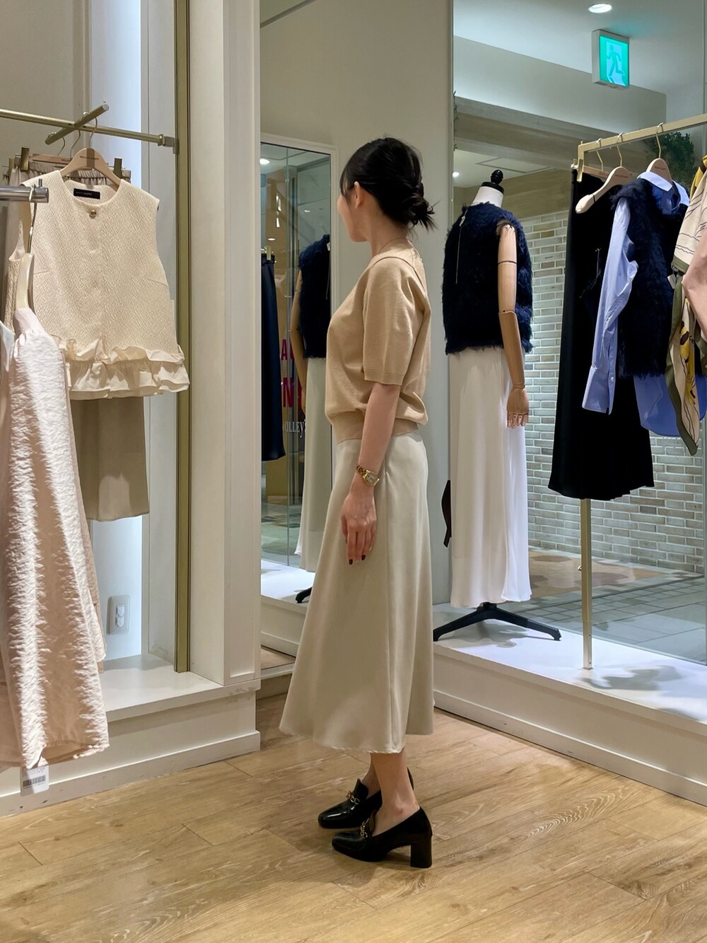 イエロー系のニット/セーター、ベージュ系のスカートを着用したレディースの秋コーディネートの3枚目の写真