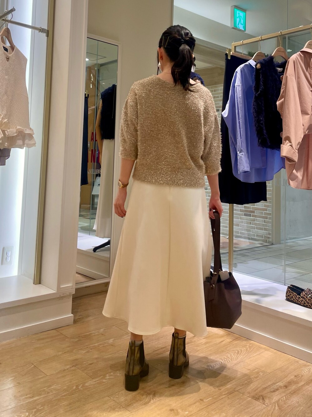 イエロー系のカーディガン/ボレロ、ホワイト系のスカート、ブラウン系のショルダーバッグを着用したレディースの秋コーディネートの5枚目の写真