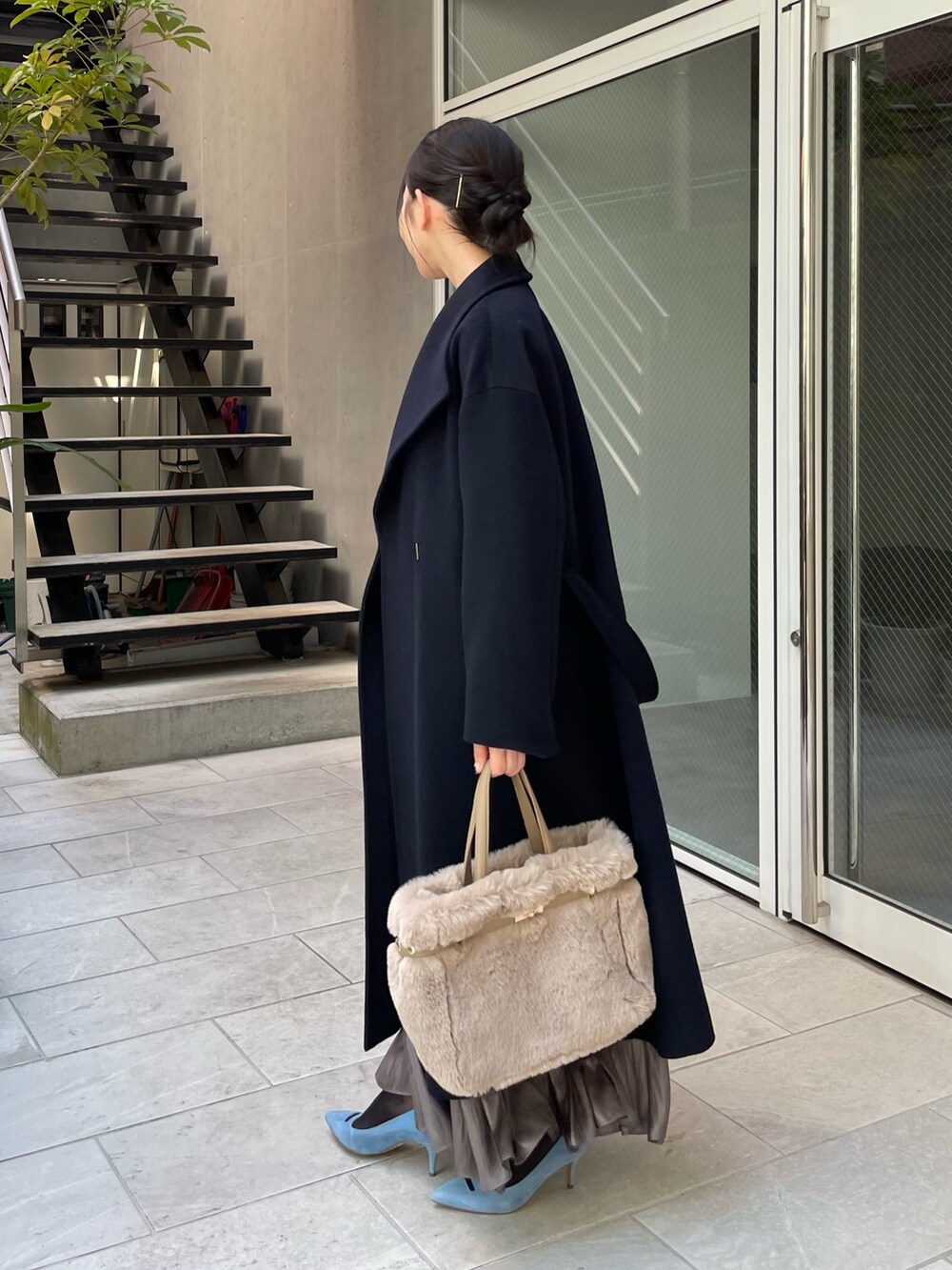 ブルー系のニット/セーター、ベージュ系のトートバッグ、グリーン系のスカートを着用したレディースの秋コーディネートの2枚目の写真