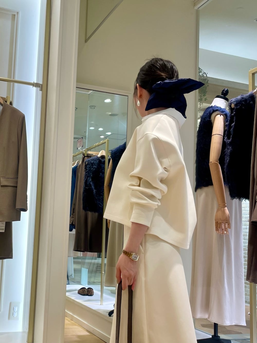 ブラウン系のショルダーバッグ、グリーン系のネクタイ、ホワイト系のTシャツ/カットソーを着用したレディースの秋コーディネートの5枚目の写真