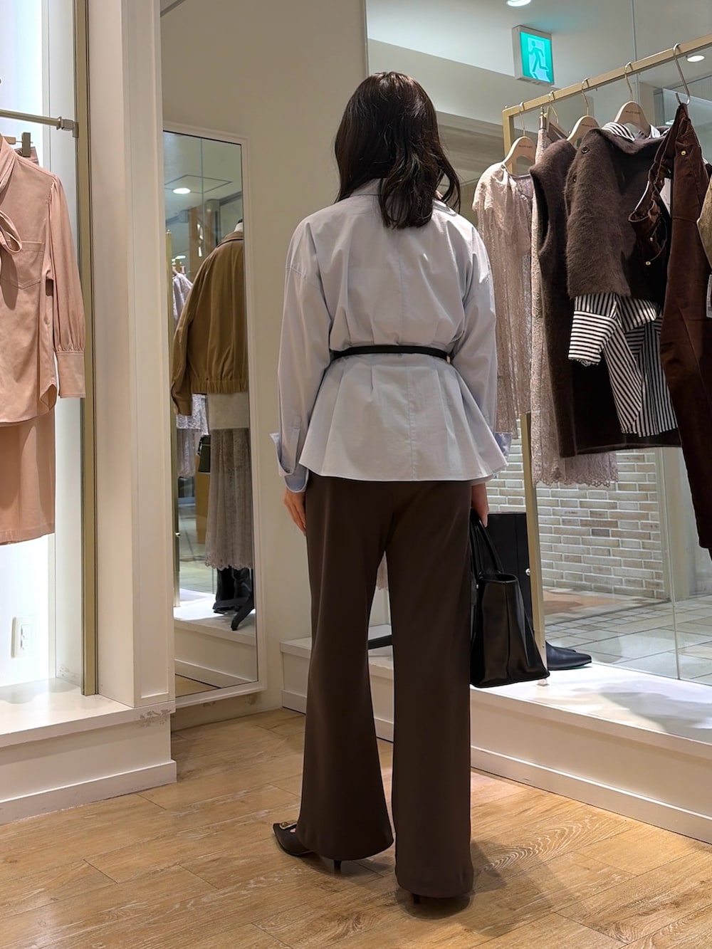 ブルー系のシャツ/ブラウス、ブラウン系のその他パンツ、ブラック系のトートバッグを着用したレディースの秋コーディネートの3枚目の写真