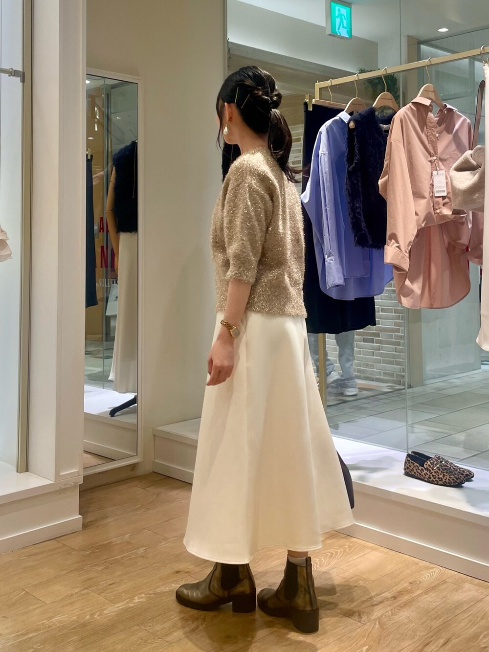 イエロー系のカーディガン/ボレロ、ホワイト系のスカート、ブラウン系のショルダーバッグを着用したレディースの秋コーディネートの2枚目の写真