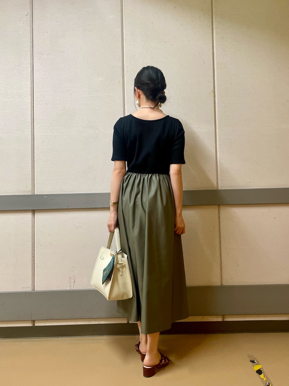 ホワイト系のショルダーバッグ、グリーン系のワンピース、ホワイト系のネックレスを着用したレディースの夏コーディネートの3枚目の写真