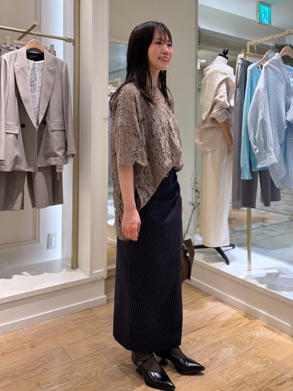 ブルー系のスカート、ブラウン系のショルダーバッグ、その他のネックレスを着用したレディースの冬コーディネートの2枚目の写真